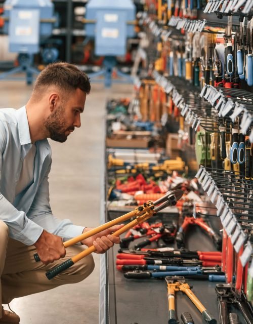 orange-colored-wire-cutter-holding-hands-man-is-hardware-shop (1)